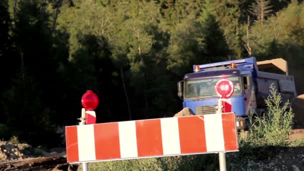 Um caminhão descarregando sua carga de solo perto do sinal de parada no local — Vídeo de Stock