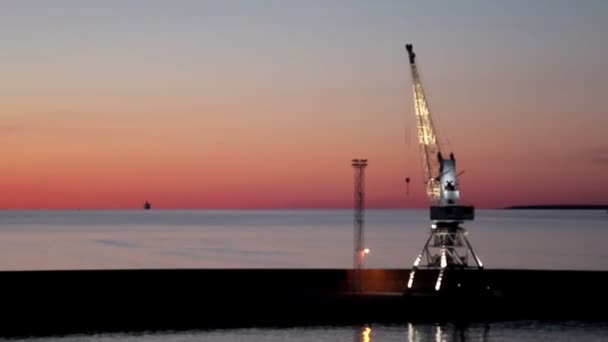 Grúa en el puerto durante la puesta del sol — Vídeos de Stock