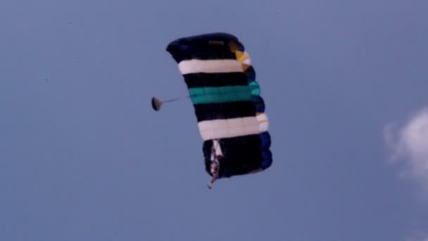 Een persoon op een parachute is veilig landing — Stockvideo