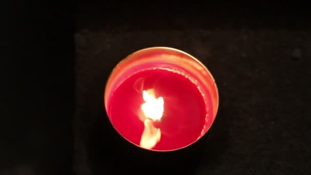 A red melting candle light inside a round glass — Stock Video