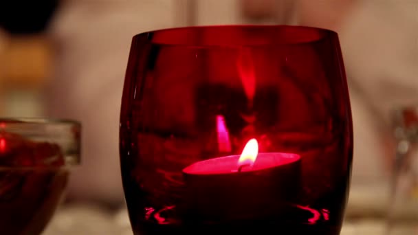 Una luz de vela dentro de un vaso rojo — Vídeo de stock