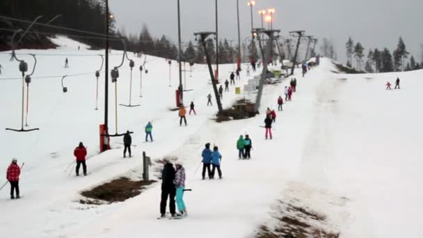 Uma vista de uma estância de esqui com muitas pessoas — Vídeo de Stock