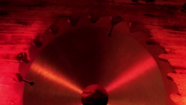 Een mes zag onder een rood-verlichte kamer — Stockvideo