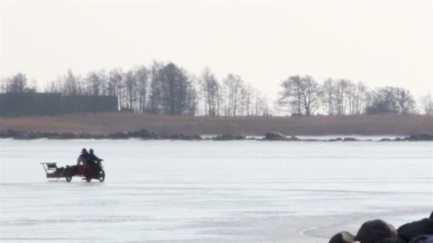 Автомобиль мотоцикла так быстро тянет сани на снегу — стоковое видео
