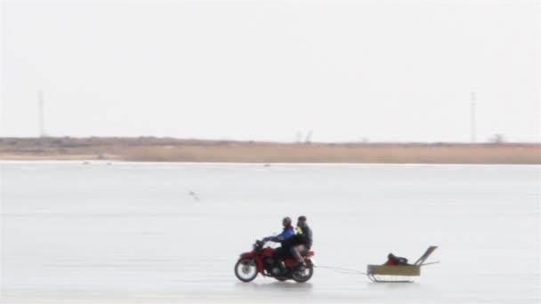 Мотоцикл, используемый для рыбалки в заснеженной местности — стоковое видео