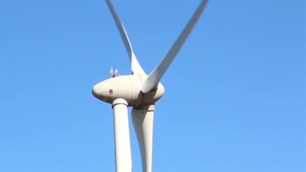 Un molino de viento blanco girando lentamente — Vídeos de Stock