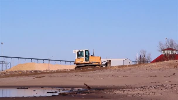 Um trator lagarta movendo um pouco de areia — Vídeo de Stock