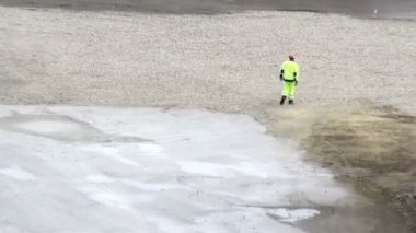 park alanına doğru yürüyen bir fabrika işçisi