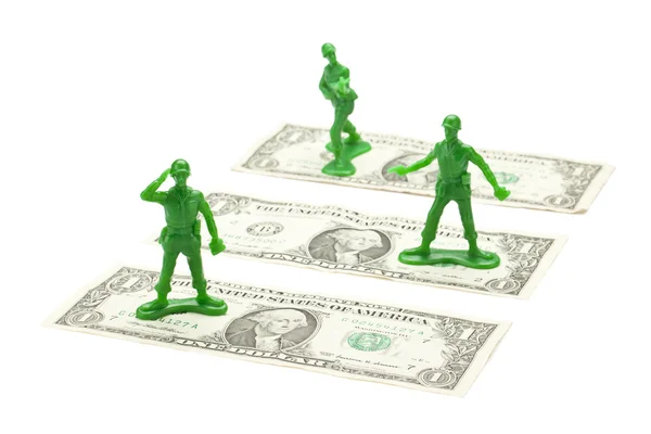 Soldado de brinquedo militar em pé sobre a nota de dólar — Fotografia de Stock