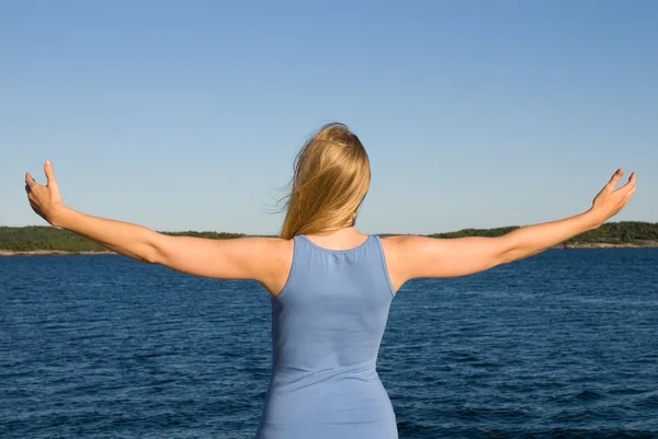 腕を大きく開いて海で若い女性 — ストック写真