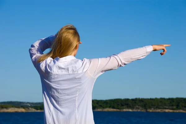 Person showing at the sea — Stock Photo, Image