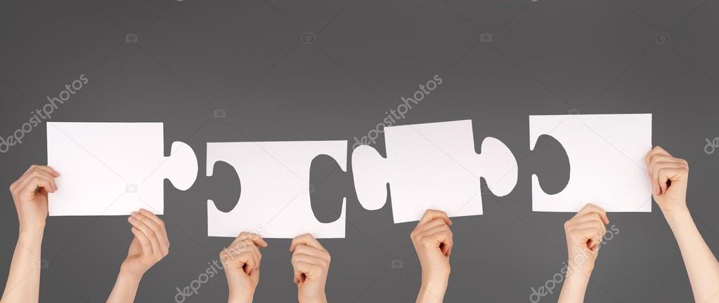 hands holding pieces of a puzzle with copy space