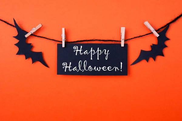 Fundo laranja com etiqueta de Halloween preto — Fotografia de Stock