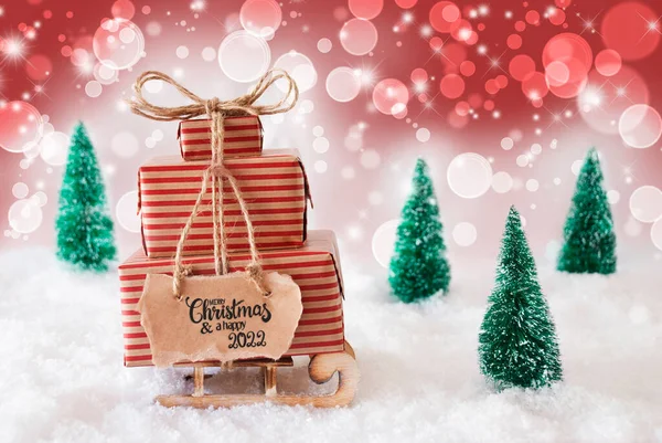 Сани, подарок, снег, счастливое Рождество и счастливый 2022 год, красный фон — стоковое фото