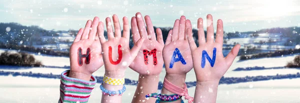 Παιδιά Χέρια οικοδόμηση λέξη ανθρώπινο, χιονισμένο φόντο χειμώνα — Φωτογραφία Αρχείου