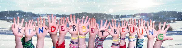 Kids Hands Holding Kinderbetreuung significa guardería infantil, fondo de invierno —  Fotos de Stock