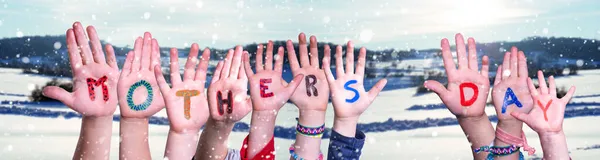 Crianças mãos construindo palavra dia das mães, neve fundo de inverno — Fotografia de Stock