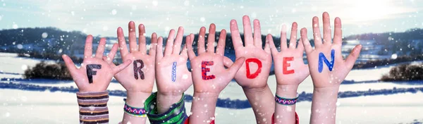 Crianças mãos construindo palavra Frieden significa paz, neve fundo de inverno — Fotografia de Stock