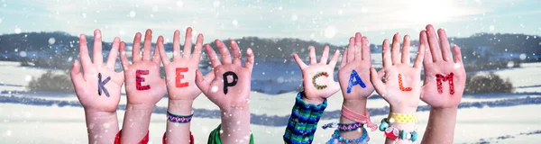 Crianças mãos segurando palavra manter a calma, neve fundo de inverno — Fotografia de Stock