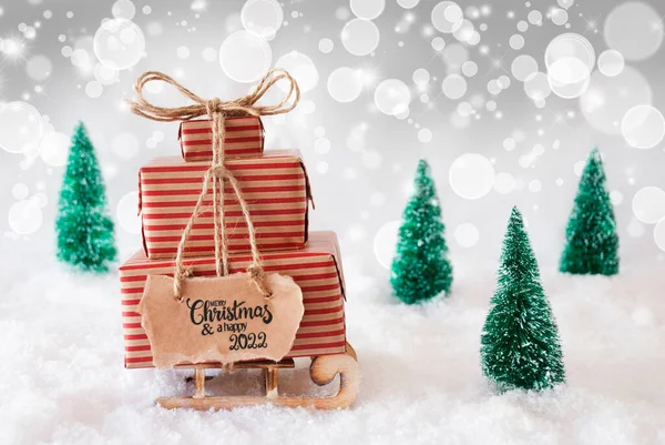 Сани, подарок, снег, счастливое Рождество и счастливый 2022 год, серый фон — стоковое фото