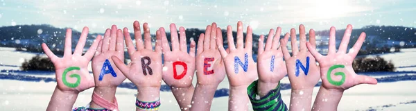Παιδιά Χέρια οικοδόμηση λέξη κηπουρική, χιονισμένο φόντο χειμώνα — Φωτογραφία Αρχείου