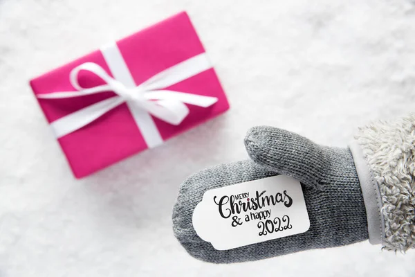 Grauer Handschuh, rosa Geschenk, Etikett, Schnee, Frohe Weihnachten und ein frohes Jahr 2022 — Stockfoto