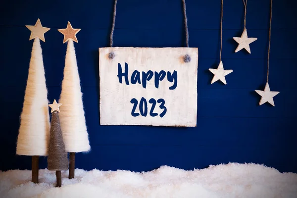 青の背景に星と白い木のようなクリスマスの装飾 白い雪が地面に 英語の書道で署名ハッピー2023 — ストック写真