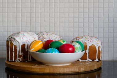 İlkbahar. Kırsal tarzda şenlik kompozisyonu. Paskalya pastası ve ahşap masaya boyanmış yumurtalar. Uzayı kopyala Düz bak