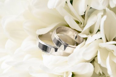 Bir buket beyaz çiçekte alyans.