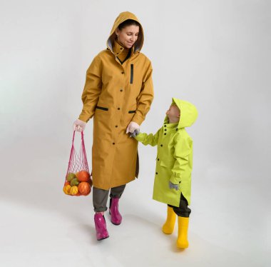 Yağmurluklu ve lastik çizmeli anne ve oğlu. Kavramsal fotoğrafçılık