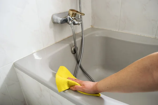 Een vrouw reinigt haar badkuip — Stockfoto