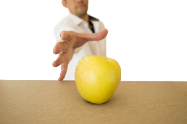 Homme attrapant une pomme sur la table — Photo