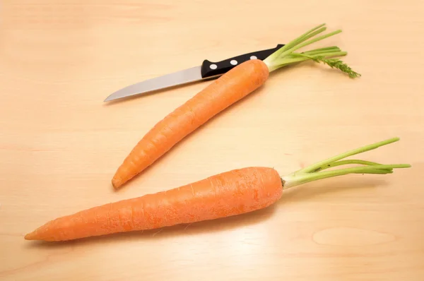 Deux carottes et un couteau sur une table — Photo