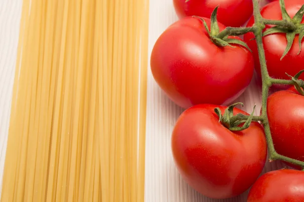 Spaghettis et tomates sur une table prête à cuire — Photo