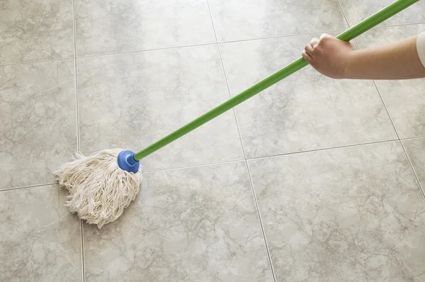 Mujer joven fregando piso con una fregona — Foto de Stock