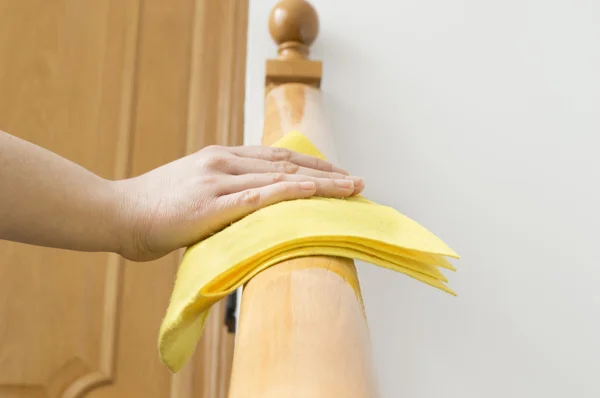 Mão limpando um corrimão de madeira — Fotografia de Stock