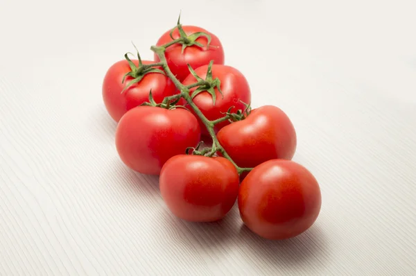 Tomates de videira em uma mesa branca — Fotografia de Stock