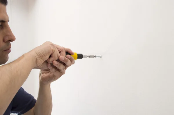 Man screwing a screw with screwdriver and copy space — Stock Photo, Image