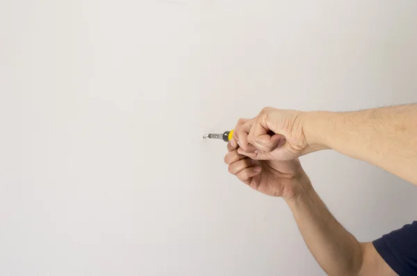 Man screwing a screw with screwdriver and copy space — Stock Photo, Image