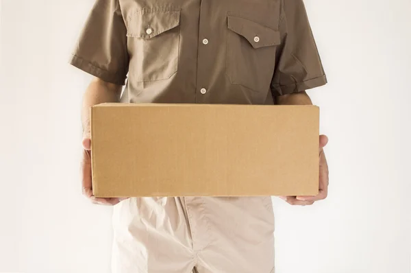 Postman having a packet for you standing in close up — Stock Photo, Image