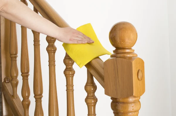 Cleaning wooden railing with yellow cloth — Stock Photo, Image