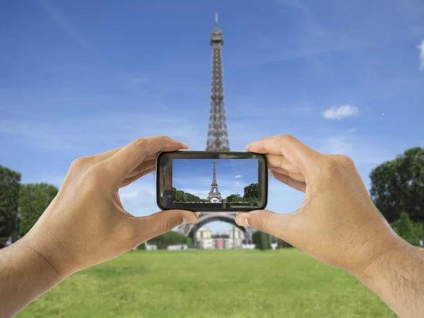 Tourist holds up camera phone at eiffel tower — Stock Photo, Image