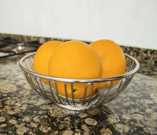 Tres naranjas en un contenedor —  Fotos de Stock