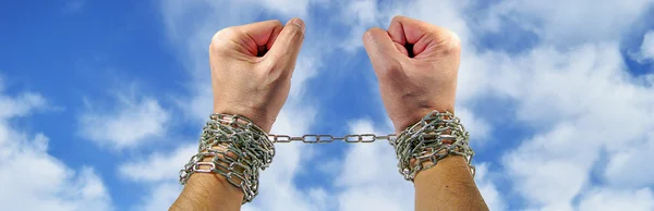 Hands with chains on sky backgroun — Stock Photo, Image