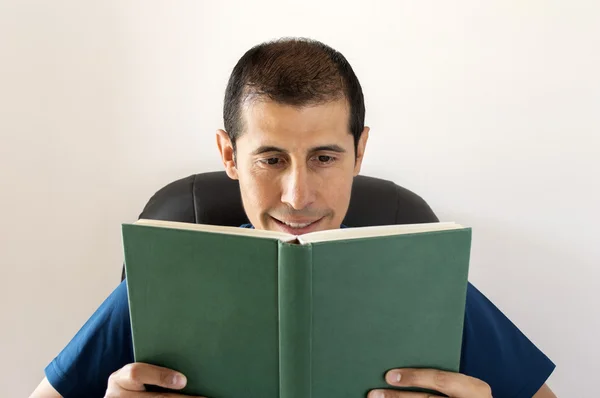 Hombre sonriente leyendo un libro — Foto de Stock