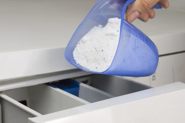 Hand pouring detergent into the washing machine — Stock Photo, Image