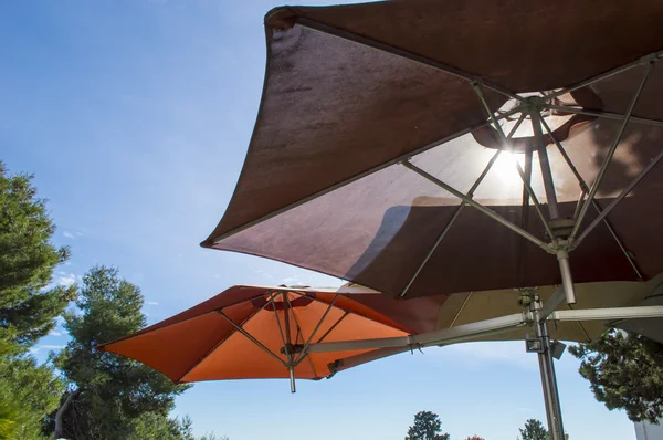 two umbrellas on a restaurant terrace