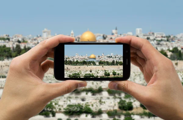 Turista sostiene el teléfono de la cámara en el jerusalem —  Fotos de Stock