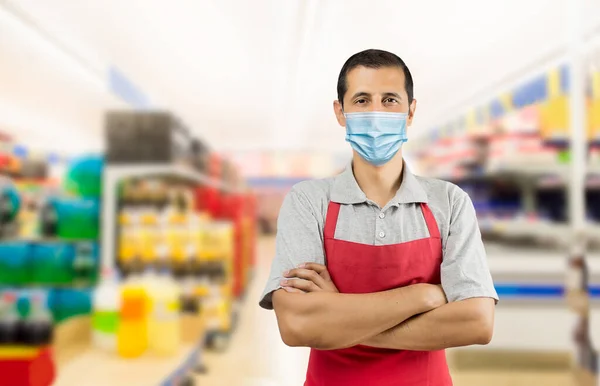 コロナウイルスを避けるためにフェームマスクを着用してスーパーマーケットで赤いエプロンで働くビジネスオーナー パンデミックライフスタイルの概念とコピースペース — ストック写真