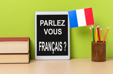 A digital tablet with the question parlez-vous francais? do you speak french? written in french, a pot wit